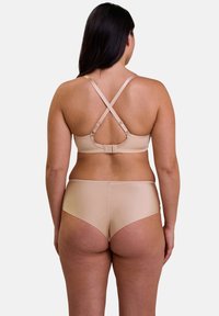 Ensemble de soutien-gorge nude et de culotte taille haute en tissu lisse, avec des bretelles croisées et une fermeture à crochet à l'arrière.