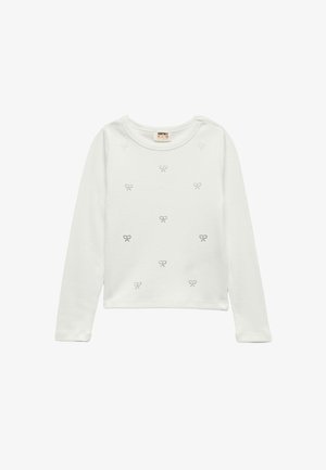 Langærmet, hvid bomulds skjorte med rund halsudskæring, prydet med små sorte sløjfemønstre jævnt fordelt over forsiden og en blød tekstur.