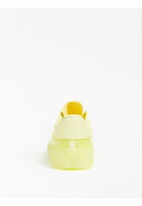 Baskets jaunes avec une tige synthétique brillante, un talon texturé et une semelle translucide. Dotées d'un col rembourré et d'une semelle intérieure coussinée.