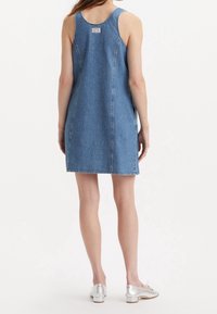 Jeansbystklänning, ljusblå, något figursydd design med sidofickor. Har stickningsdetaljer och en vävd etikett på baksidan.