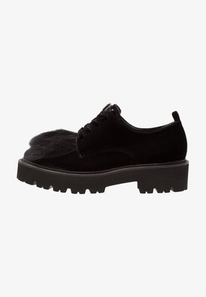 Chaussure noire à lacets avec un bout en fausse fourrure texturée, un dessus en velours, une épaisse semelle en caoutchouc et des crampons prononcés. Design élégant avec des matériaux contrastés.