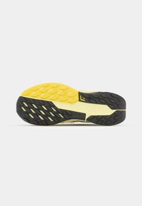 Semelle de chaussure de course avec un design en caoutchouc noir et jaune. Comprend des stries texturées et un motif de semelle pour l'adhérence.