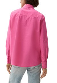 Heldroze langslavende shirt met een kraaghals, knoopmanchetten en een ontspannen pasvorm. Glad van textuur, zonder zichtbare patronen.