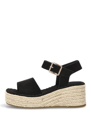 Sandalia de cuña de ante negro con suela plataforma gruesa de yute trenzado y correa de hebilla dorada en el tobillo, vista lateral sobre fondo blanco.