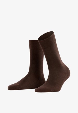 Chaussettes en coton marron avec texture côtelée, longueur mi-mollet et renfort à la pointe. Design lisse avec un minimum de détails de couture.