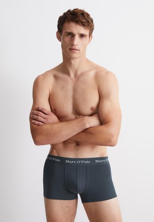 Dunkelgraue Boxershorts mit einem schwarzen Bund, der mit dem Logo "Marc O'Polo" versehen ist. Hergestellt aus einem glatten, elastischen Material, das eng anliegt.