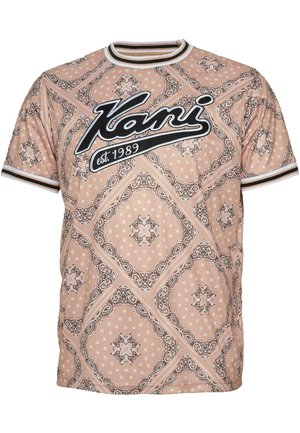 T-shirt a maniche corte con scollo rotondo in marrone chiaro con dettagli a fantasia. Presenta scritte nere e bordi bianchi e neri a contrasto.