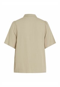 Chemise beige à manches courtes avec un col plat, vue de dos, présentant une coupe ample et légèrement structurée.