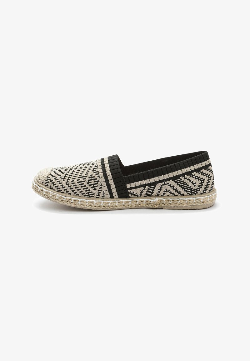 Matala espadrille musta ja beigen geometrisessä kuviotuksessa. Varustettu kudotulla juutti-pohjalla ja joustavalla nauhalla istuvuuden takaamiseksi. Pehmeä kangaspäällinen.