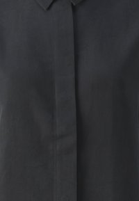 Mørkeblå linnedskjorte med button-down krave og en forreste placket med en glat tekstur og minimale syninger.
