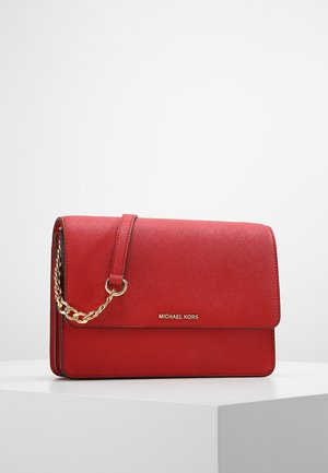 Rød skuldertaske i læder fra Michael Kors med guldkædedetalje, rektangulært formet og med klaplukning, udstillet på en hvid piedestal.