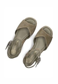 Olijfgroene suède sandalen met kruisbanden, open teen en enkelgesp, voorzien van een textuur in de binnenzool en een lage wiggle.