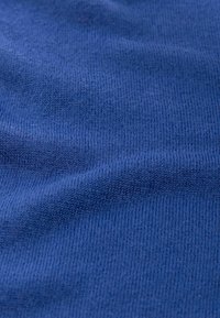 Kék kötött anyag sima textúrával és finom bordás mintával, mély és egységes színnel a felületen.
