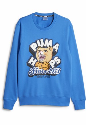 Sweat-shirt bleu à manches longues avec une tête de puma rugissante, deux ballons de basket et le texte « Puma Hoops Since 1973 » sur le devant.