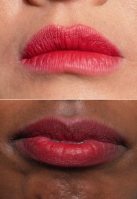 Due set di labbra in primo piano: la parte superiore è di un rosa chiaro opaco e liscio; la parte inferiore è di un rosso opaco più scuro con una texture visibile e linee sottili.
