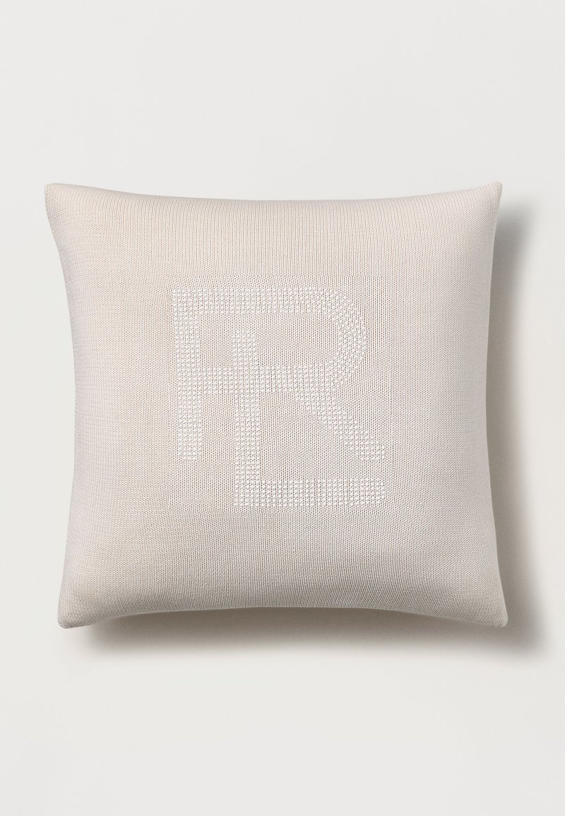 Rectangular cushion in light beige fabric featuring a textured, white "FR" design. Smooth surface with subtle detailing and rounded corners.
