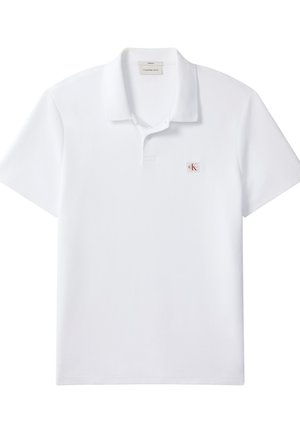 Polo blanco de manga corta con cuello, tapeta de dos botones y pequeño parche con el logo de Calvin Klein en el pecho izquierdo.