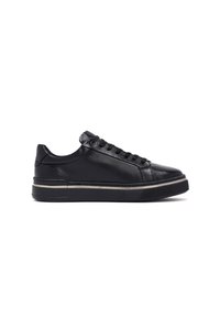 Sneaker in pelle nera con punta rotonda, lacci piatti e una striscia argento a contrasto lungo la suola. Texture liscia e design minimale.