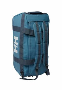 Niebieska torba podróżna z wyściełanymi paskami, dwoma uchwytami bocznymi i białym logo. Wykonana z trwałego materiału, ma elegancki prostokątny kształt oraz poziome akcenty.