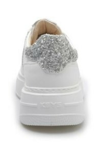 Sneaker bianco con un accento di glitter argento testurizzato sul tallone, caratterizzato da una suola spessa bianca e una superficie liscia. L'etichetta riporta la scritta "KEYS."