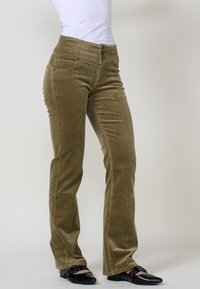 Maslinaste kord pantalone ravnog kroja, s visokim strukom i zatvaranjem na tri dugmeta, dopunjene prednjim džepovima i teksturiranom završnom obradom.