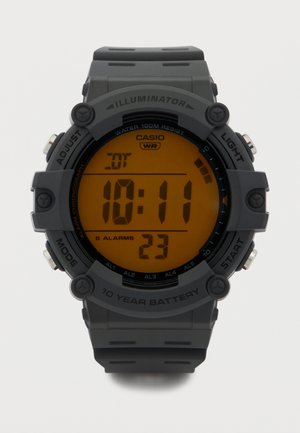 Digital Casio watch with black strap, orange backlit display showing 10:11, 5 alarms, water resistant up to 100 meters, 10-year battery.