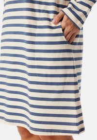 Randig klänning i off-white och marinblått, tillverkad av mjukt tyg, med en sidficka och långa ärmar med en avslappnad passform.