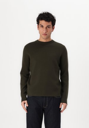 Olivenfarvet crewneck sweater lavet af blødt stof. Slim fit design med lange ærmer, minimale sømme og en glat overflade. Båret med mørke jeans.