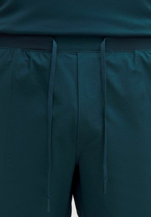 Tīra šorti ar teksturētu audumu, jostasvietā ar aukliņu un sānu kabatām. Iezīmē gludu virsmu un elastīgu jostasvietu.