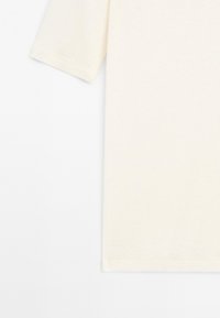 Krátký rukáv, jednobarevné off-white bavlněné tričko s kulatým výstřihem, vystavené na bílém pozadí.