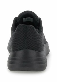 Black athletic shoes with a mesh upper, rounded heel, and a textured sole. Features a cushioned collar and minimalistic design.
