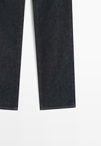 Jeans in denim dritto blu scuro mostrati su uno sfondo bianco con dettagli di cucitura visibili.