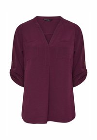 Burgunderfarbene Bluse mit V-Ausschnitt, zwei Brusttaschen und hochgekrempelten Ärmeln. Hergestellt aus strukturiertem Stoff mit dezenten Nähdetails.