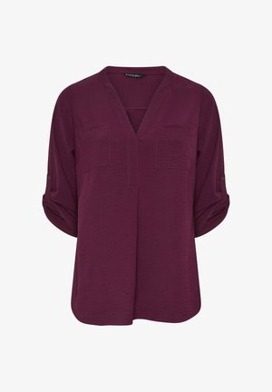 Bordeaux-paitapusero, jossa on v-mallinen kaula-aukko, kaksi rintataskua ja käärityt hihat. Valmistettu teksturoidusta kankaasta, jossa on hienovaraisia ompeluyksityiskohtia.