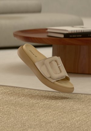 Sandale beige à enfiler avec une large bride, un accent de boucle rectangulaire, une semelle intérieure rembourrée et une semelle légère et flexible.