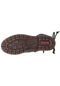 Semelle de chaussures de randonnée noires avec un crampon en caoutchouc robuste pour une meilleure adhérence. Présente un logo en relief et des détails en motif pour plus de traction. Bords renforcés.