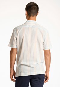 Camicetta a maniche corte in tessuto leggero con righe verticali blu e bianche, caratterizzata da un colletto con bottoni e un orlo dritto.