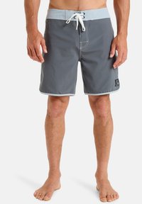 Men's swim trunks in dark gray with light blue waistband. Features a drawstring closure and white stitching. Short length, lightweight fabric.