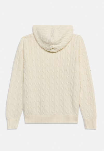Πουλόβερ με κουκούλα, πλεκτό σχέδιο με κορδόνια σε κρεμ χρώμα, με μακριά μανίκια και ριμπ μανσέτες και τελείωμα, εμφανίζεται από πίσω.
