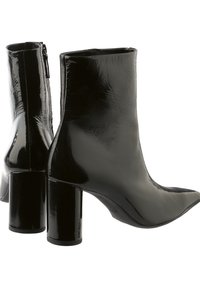 Bottines noires brillantes avec un bout pointu et un talon épais. Texture lisse, fermeture éclair à l'arrière et silhouette élégante.