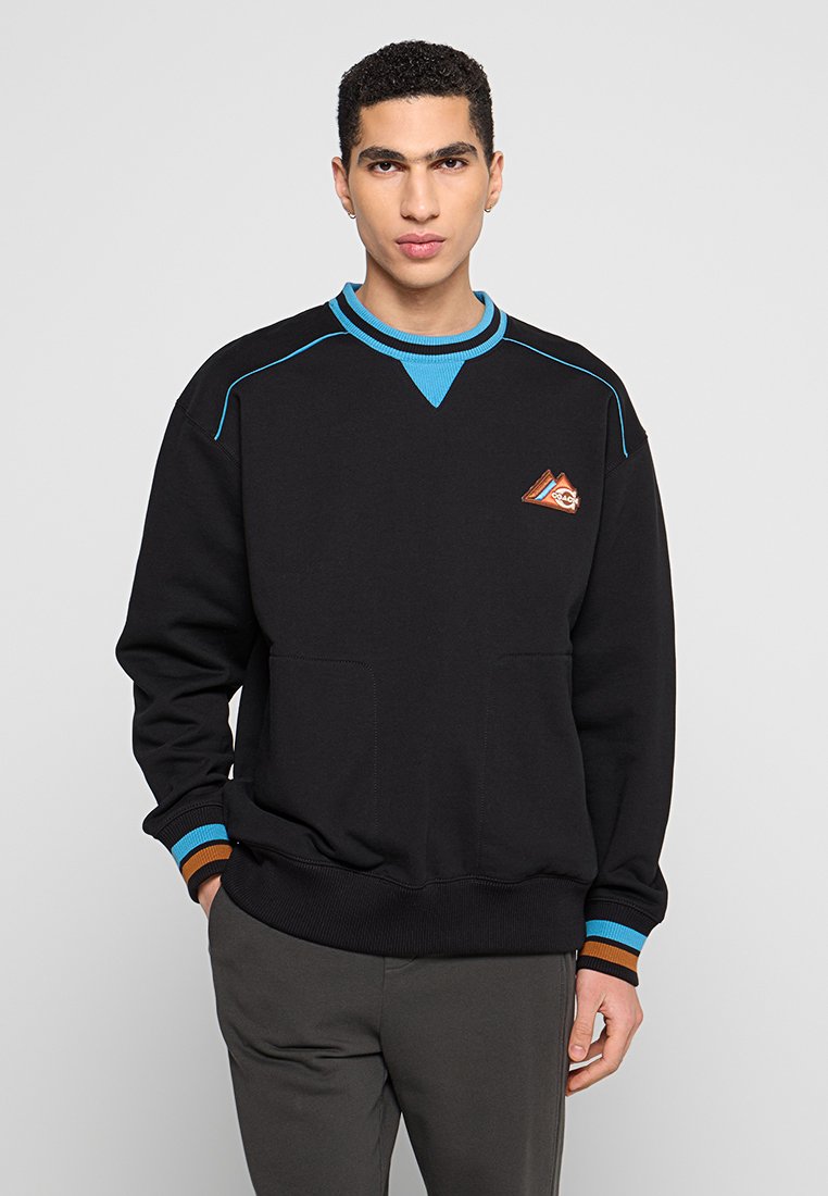 Czarny sweter z niebieskim kołnierzykiem i akcentami, z dwoma przednimi kieszeniami i małym logo na klatce piersiowej. Żebrowane mankiety i dół.