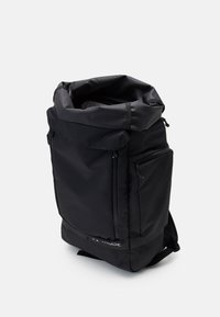 Zaino nero con superficie texturizzata, design a roll-top, multiple tasche con cerniera, spallacci imbottiti e logo sulla parte anteriore.