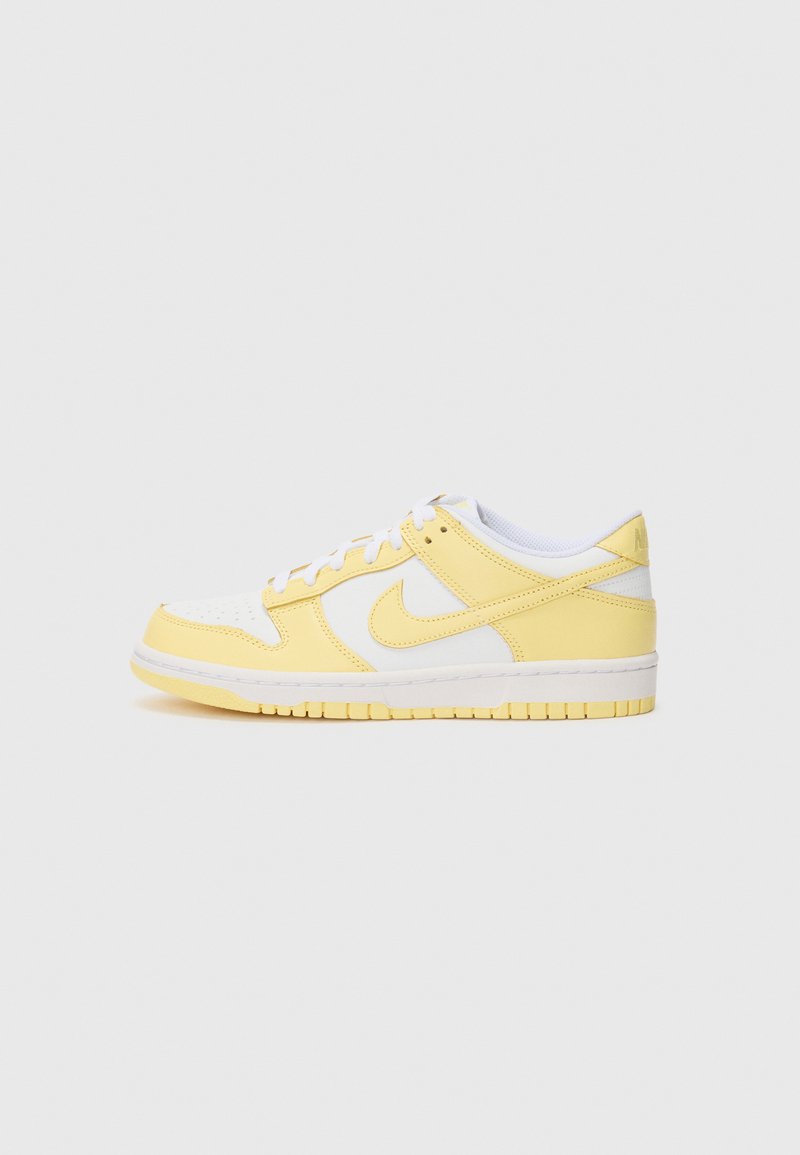 Nike Dunk Low-sneakers har en hvit lær tåboks, gule lærpaneler og en teksturert gul såle. Klassisk snøringsdesign.