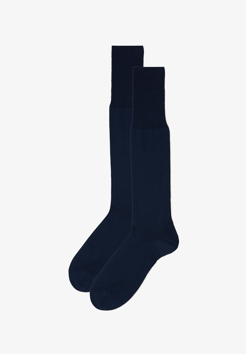 Marineblå knælange sokker lavet af et blødt materiale med en glat tekstur og ribbede manchetter. Enkel, ensartet design uden mønstre.