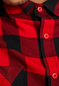 Czerwona i czarna koszula w kratę wykonana z bawełny, z zapięciem na guziki w kontrastowym czerwonym kolorze, kieszenią oraz fakturowanym wzorem tkaniny.