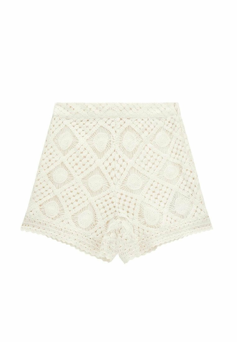 Pantaloni corti bianchi all'uncinetto con un motivo a diamante, bordi a scallop e una finitura testurizzata per un design leggero e traspirante.