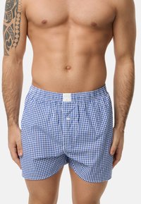 Modré a bílé kostkované boxerky s elastickým pasem, s předním zapínáním na knoflík a měkkou, lehkou tkaninou.
