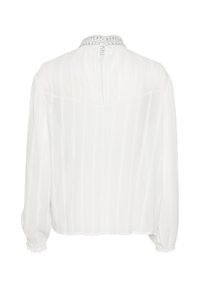 Hvid, langærmet bluse lavet af letvægtsstof. Har et plisseret design og en dekorativ perlekant med en knaplukning på ryggen.