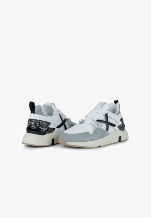Des baskets de sport avec une tige en maille blanche, des accents en suède gris, du cuir de serpent noir au niveau du talon et une semelle épaisse crème.