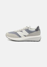 Baskets grises et bleues en matériaux de daim et de mesh, logo blanc proéminent sur le côté, accents texturés et semelle intermédiaire blanche épaisse.